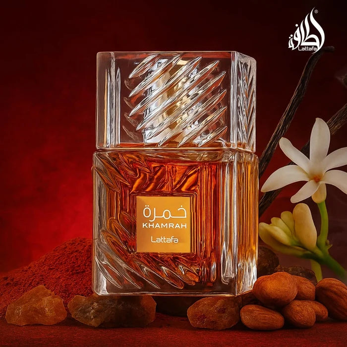 Lattafa Khamrah perfume bottle with almonds and flowers on a red background