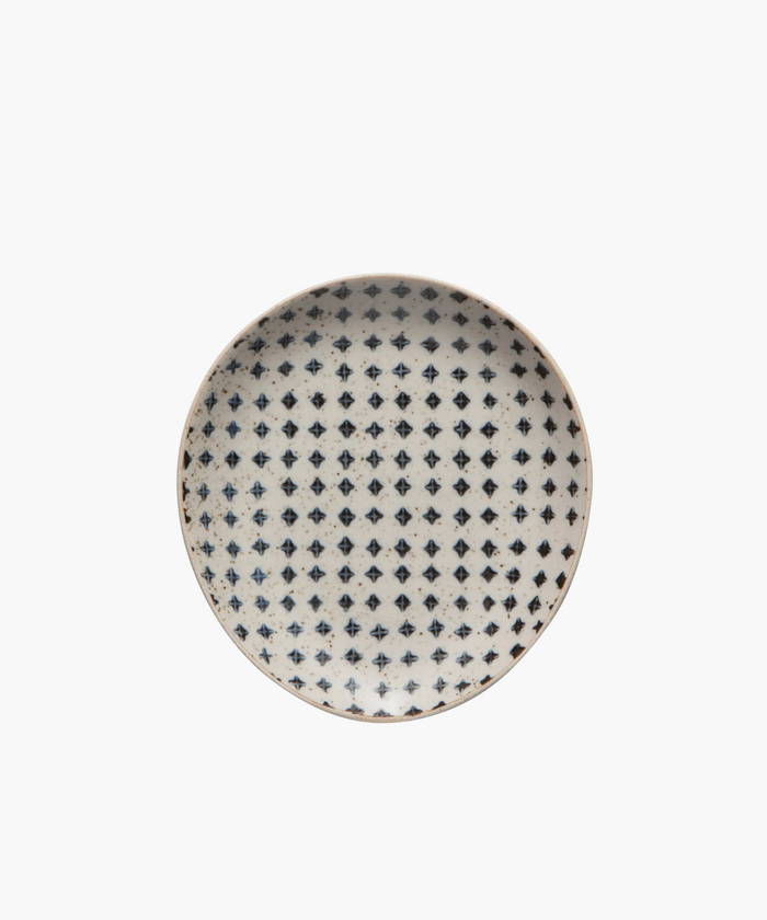 A round ceramic spoon rest with a white background features a repeating pattern of small, dark blue cross shapes, creating a rustic and elegant look. | Wildwood Home Co.
