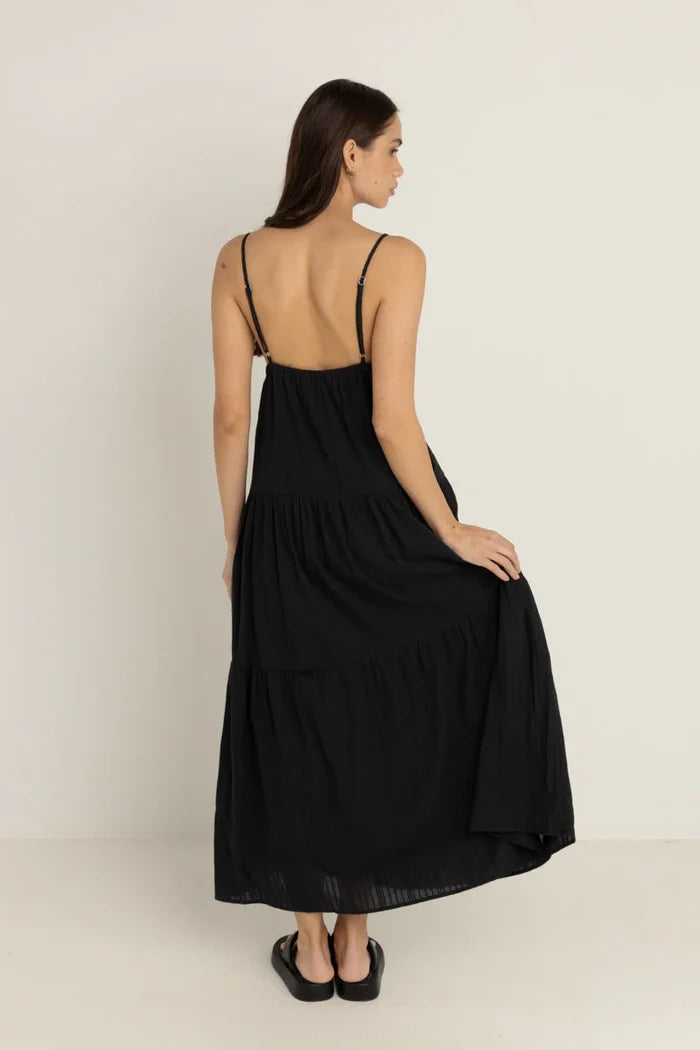 Woman wearing a rhythm jaci black dress with thin straps on a plain background