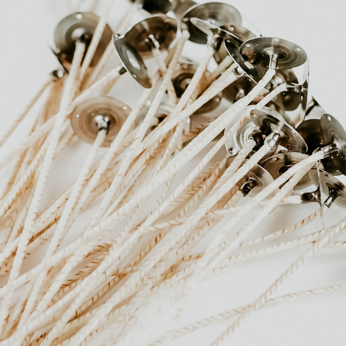 A collection of Ultra-Core Wicks with natural white color and patented open-knit construction, designed for container candles.