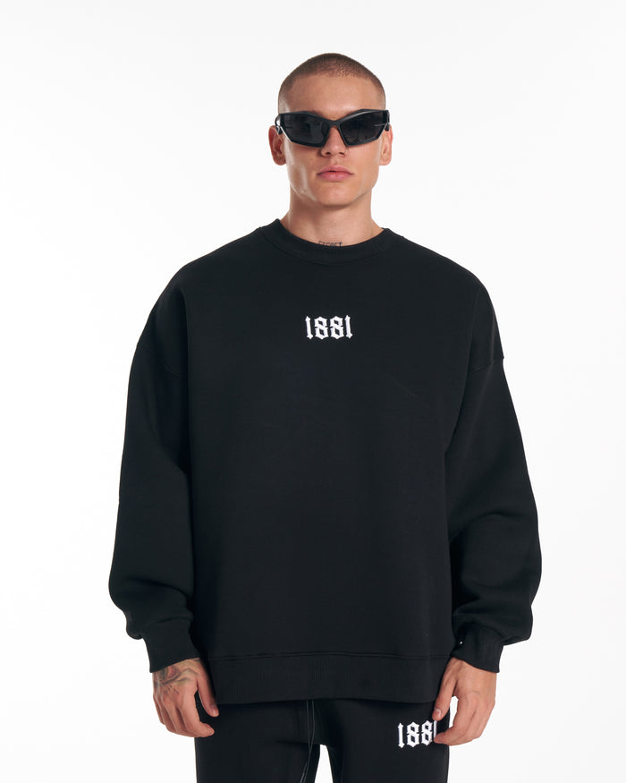 Martin Valen 1881 oversized black sweatshirt with white embroidered logo, centered front view including trouser detail