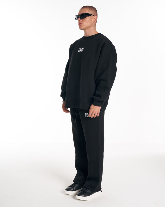 Martin Valen 1881 oversized black sweatshirt with 3D embroidery, three-quarter profile view showing dropped shoulders and relaxed fit