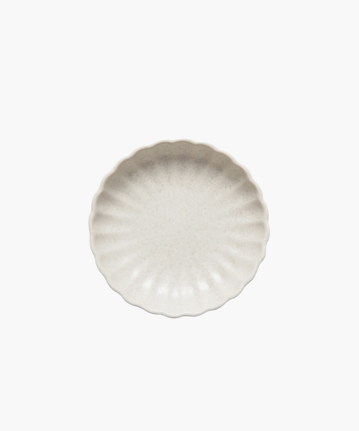 A round, cream-colored stoneware dish with a textured, scalloped edge, conveying a sense of elegance and simplicity against a plain white background. | SW Home