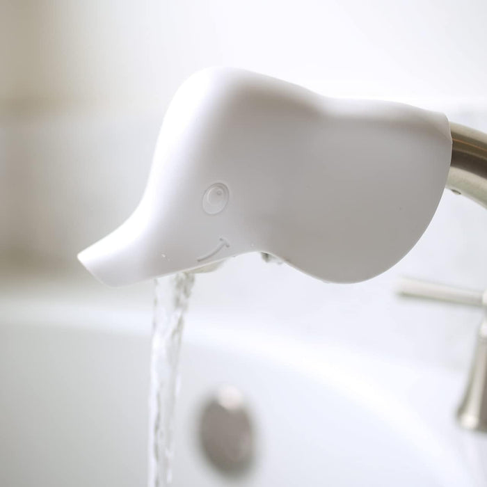 The Baby Bathtime Essentials Bundle includes a white duck head-shaped safety spout guard that fits onto a bathtub faucet, letting water flow gently from the duck’s beak into the tub.