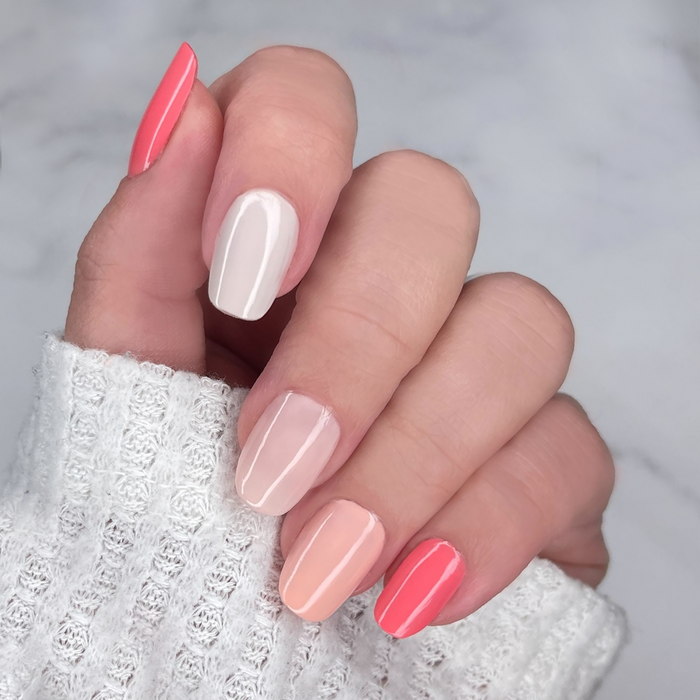 Better Than Roses coral and sheer pink mix-and-match manicure on a light skin tone