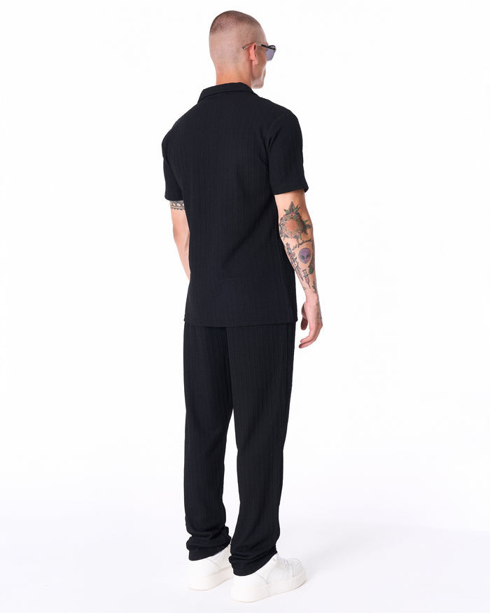 Martin Valen Breeze Fit black tracksuit, mid-leg shot showing relaxed trousers and white sneakers