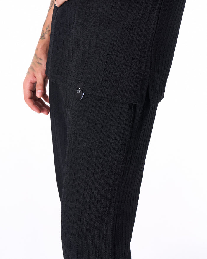 Martin Valen Breeze Fit men's tracksuit in black, full-leg shot with relaxed pant length draping over white sneakers