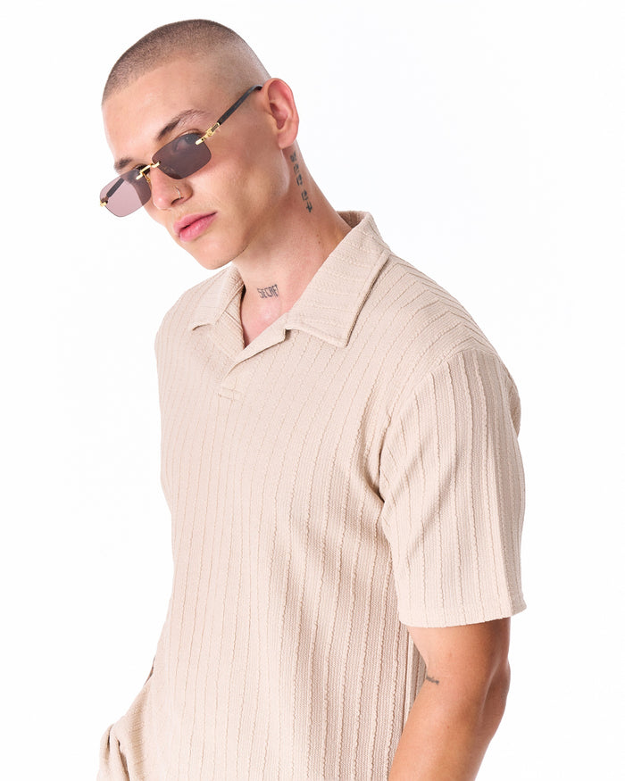 Martin Valen Breeze Fit men's tracksuit in cream, close angled crop of torso and tattooed arm with sunglasses