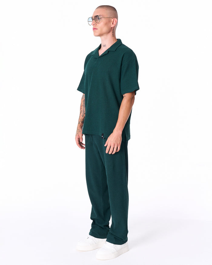 Martin Valen Breeze Fit men's tracksuit in dark green, three-quarter side view showing open collar