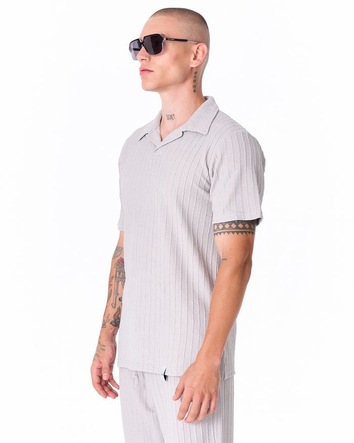 Martin Valen gray short-sleeve tracksuit top in ribbed fabric, side profile view with model wearing sunglasses