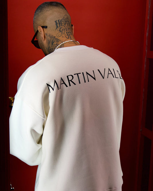 Martin Valen oversized white sweatshirt seen from back with large logo on upper back, pearl necklace and neck tattoo visible