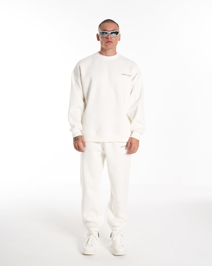 Martin Valen oversized white sweatshirt front view, chest-level close-up with small chest logo and model wearing white sunglasses