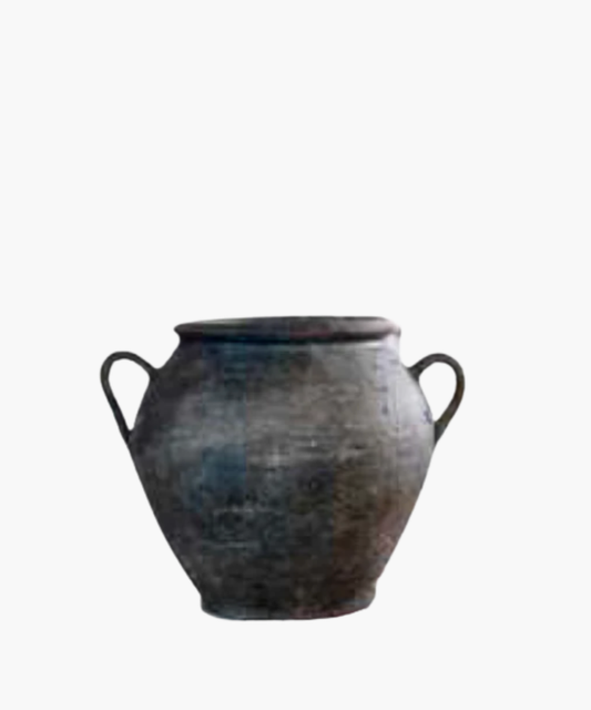 Aged, dark clay pot with two curved handles on each side. The surface is textured, showing signs of wear, conveying a sense of history and rustic charm. | Wildwood Home Co.