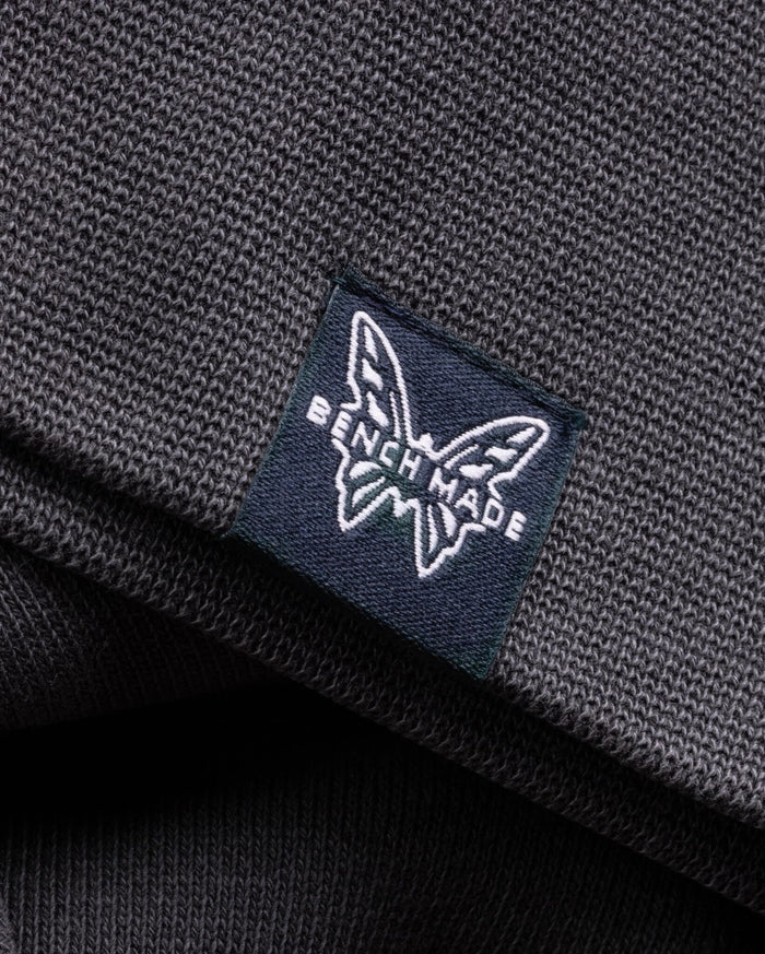 Navy Benchmade Butterfly Logo Label - Close-up Detail on Grey Cotton Fabric | Benchmade Knife Co.