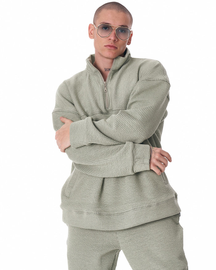 Martin Valen khaki high‑collar half‑zip tracksuit, full standing view highlighting straight‑leg pants and white sneakers