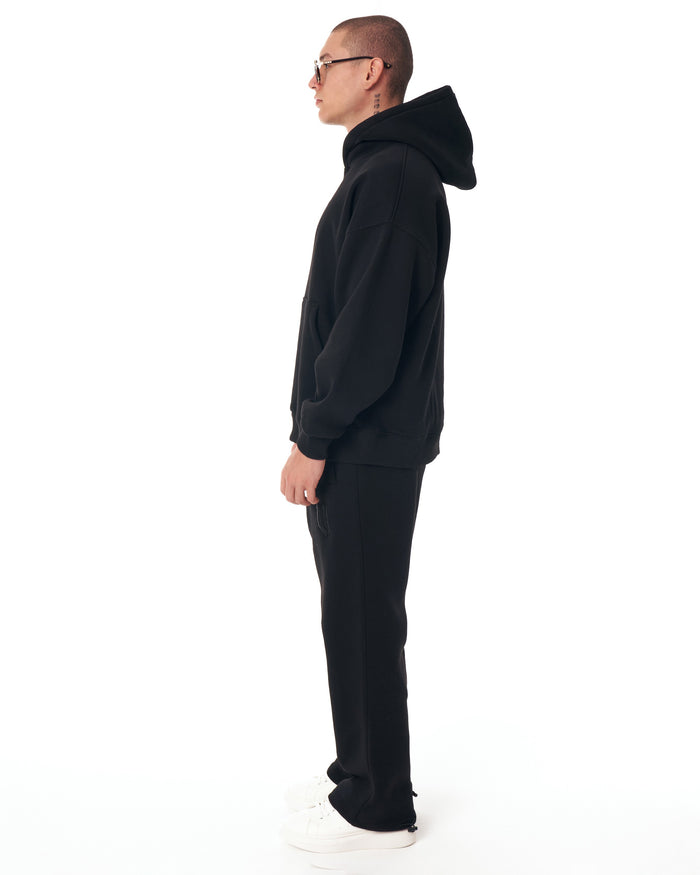 Martin Valen Insignio 3D designer embroidered oversized black hoodie tracksuit, side profile showing hood and kangaroo pocket.