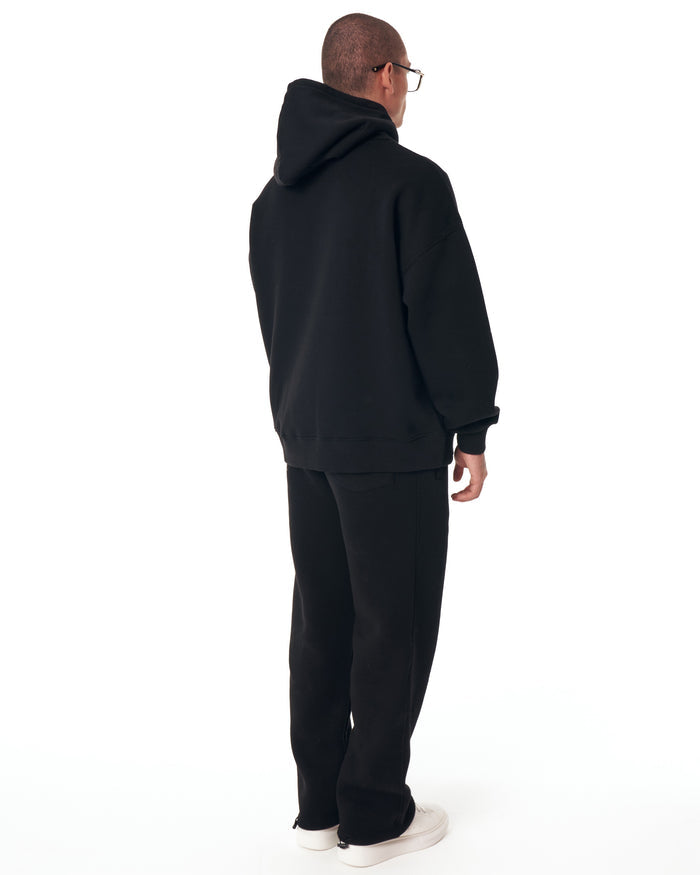 Martin Valen Insignio 3D embroidered oversized black hoodie tracksuit, full side view showing matching joggers and white sneakers.