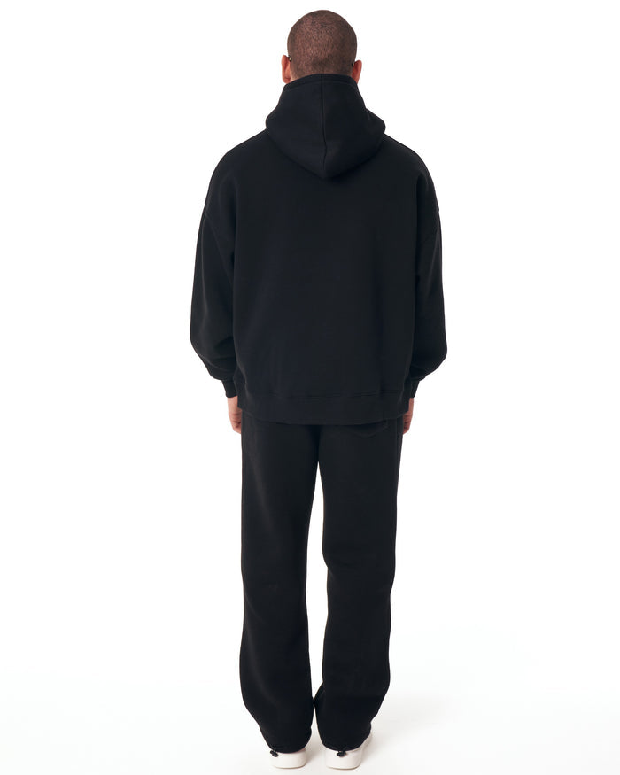 Martin Valen Insignio 3D embroidered oversized black hoodie tracksuit, three-quarter back view showing the hooded back and pant leg.