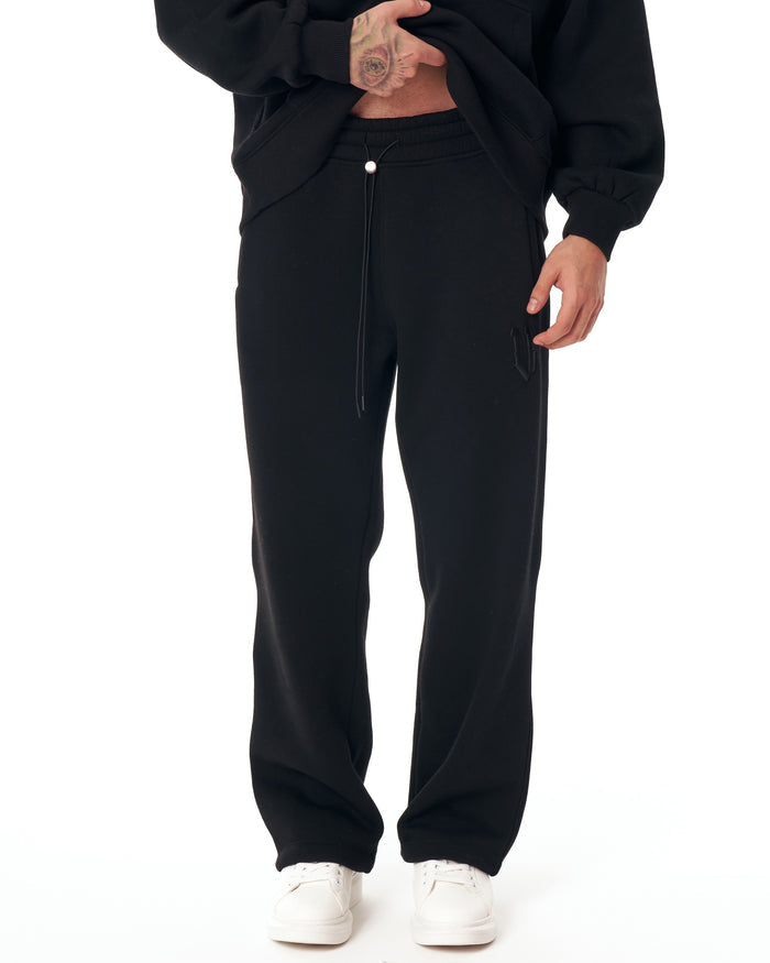 Martin Valen Insignio black tracksuit mid-section view showing kangaroo pocket and relaxed sleeve shape