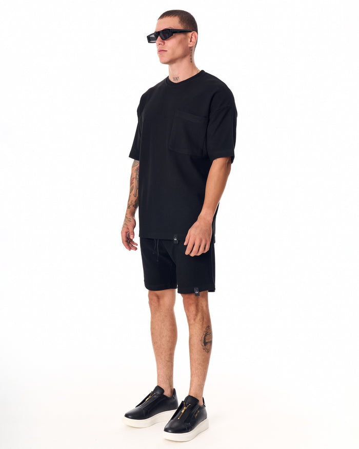 Martin Valen men's full black short tracksuit, side view highlighting drawstring waistband and matching shorts