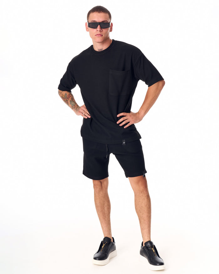 Martin Valen men's full black short tracksuit, full-leg view highlighting black shorts and black sneakers with white soles