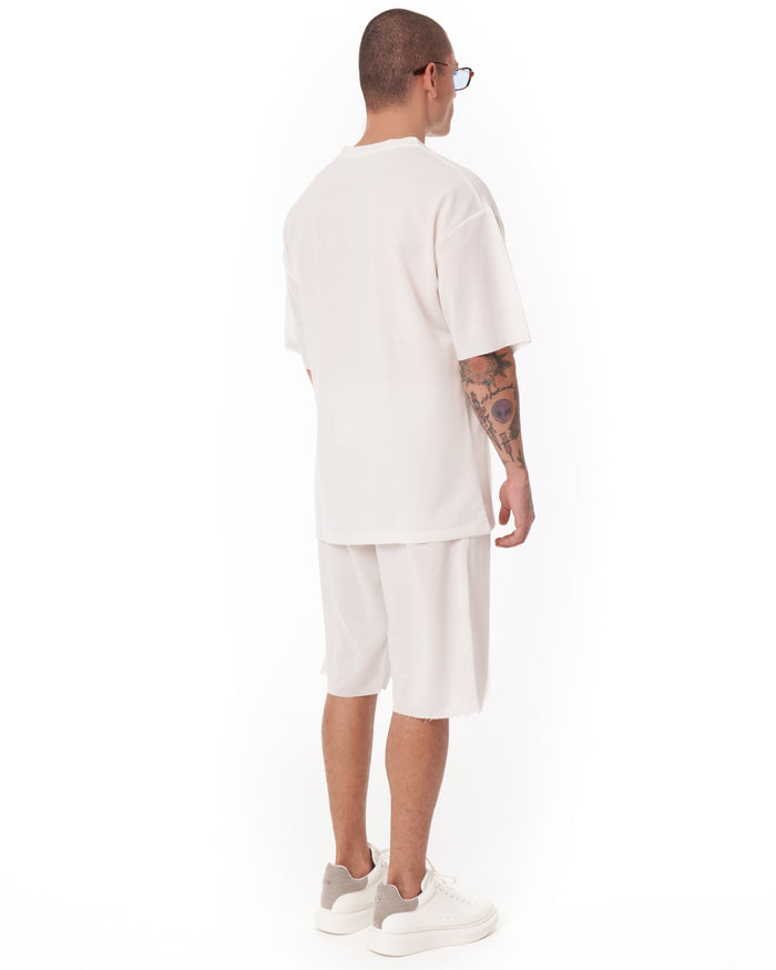 Martin Valen men's white oversize shortsuit lateral view showing long tee and shorts, black hem tag visible