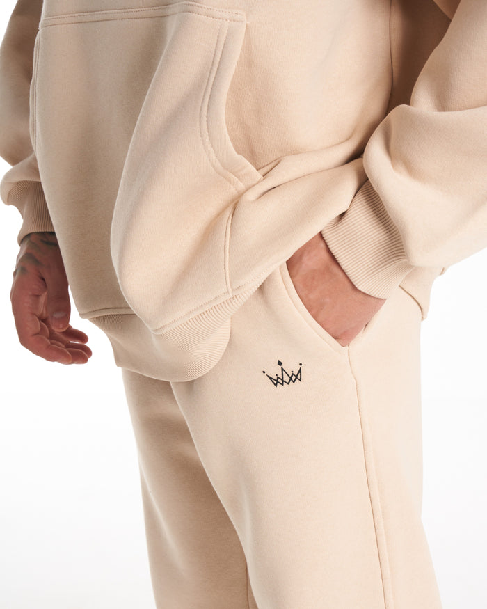 Martin Valen Regalia Crown beige tracksuit set, full standing view showing oversized fit and white sneakers