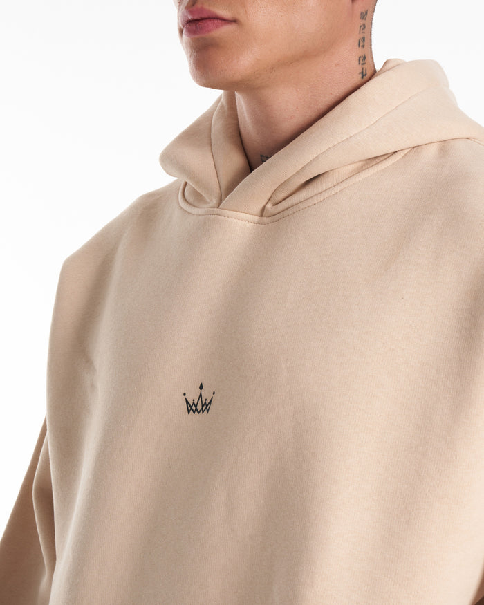 Martin Valen Regalia Crown beige hoodie, close-up of kangaroo pocket and ribbed cuff with hand partially inside