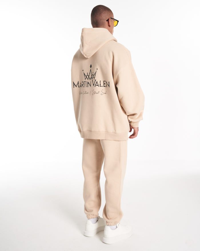 Martin Valen Regalia Crown oversized beige hoodie and tracksuit bottoms, back view with large black crown logo printed on the back