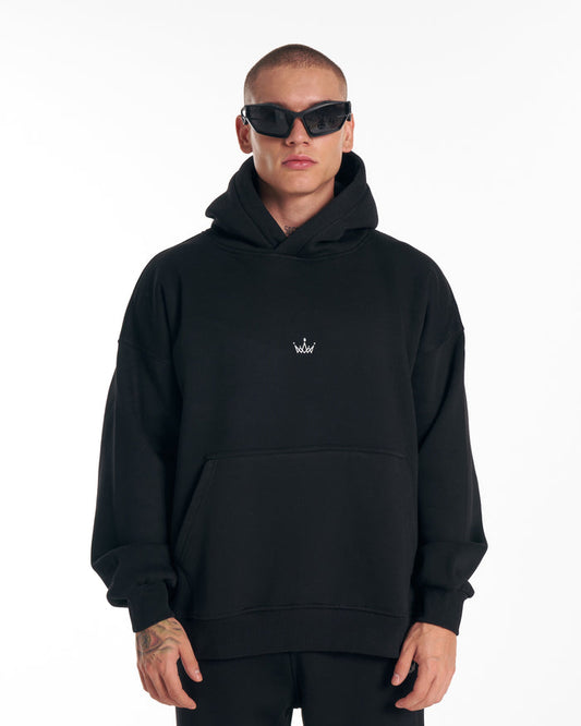 Martin Valen Regalia Crown oversized black hoodie, front view on model wearing black sunglasses with small white crown logo at chest