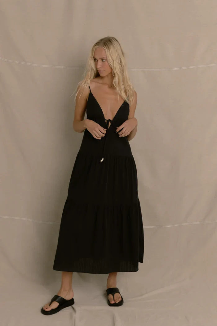 Woman wearing a rhythm jaci dress in black against a beige background