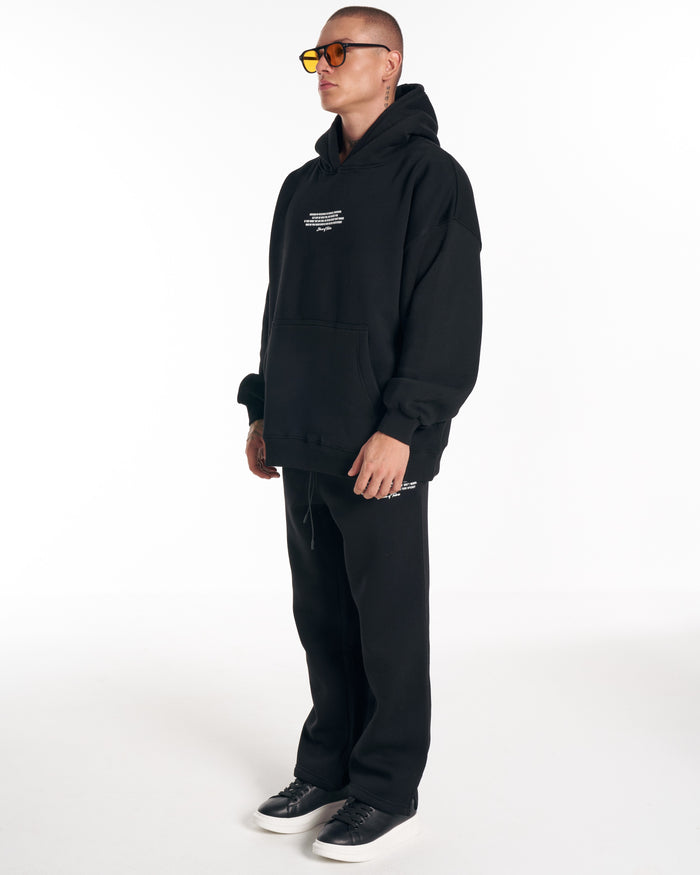 Martin Valen Rumi black tracksuit full-length view, oversized hoodie and matching pants with white printed detail