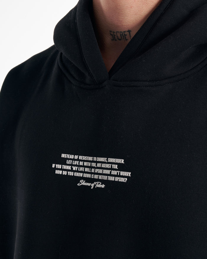 Martin Valen Rumi oversized black hoodie, close-up front view of hood and neckline showing small white printed text