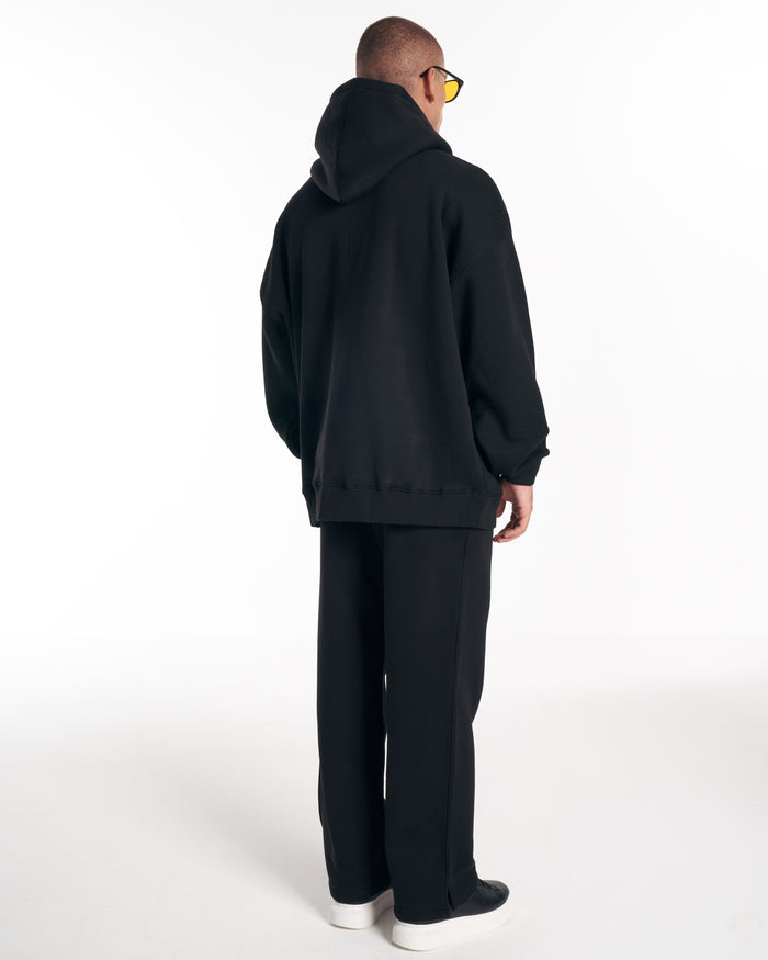 Martin Valen Rumi oversized black hoodie, three-quarter rear view with hood up and plain back
