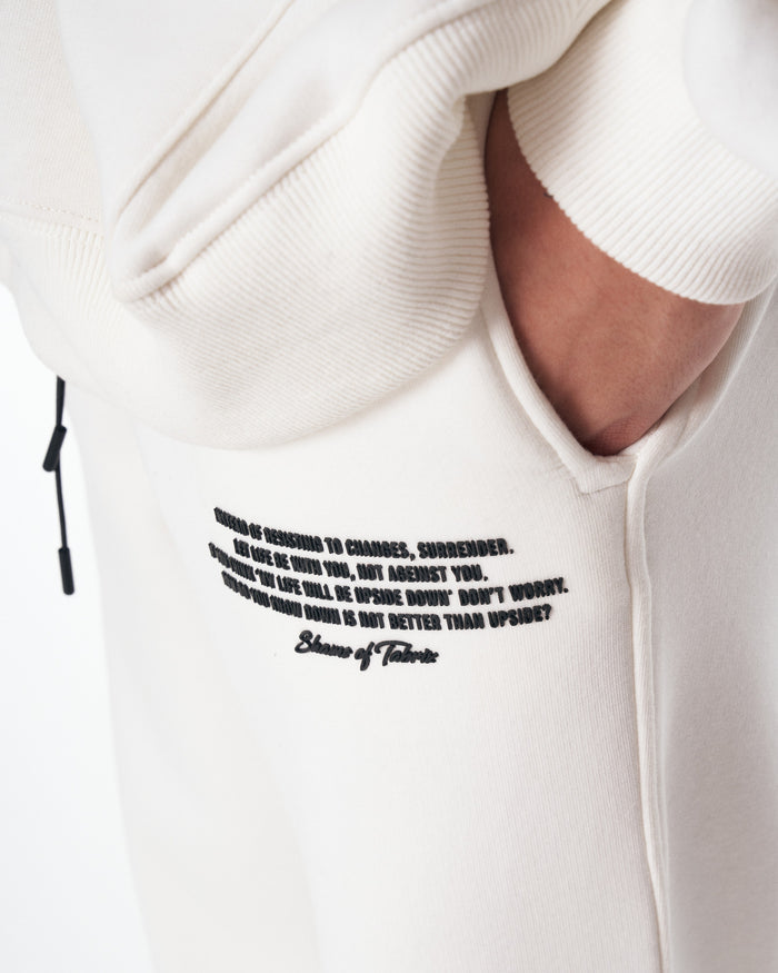 Martin Valen Rumi oversized white tracksuit, low-angle view of trousers and matching white sneakers