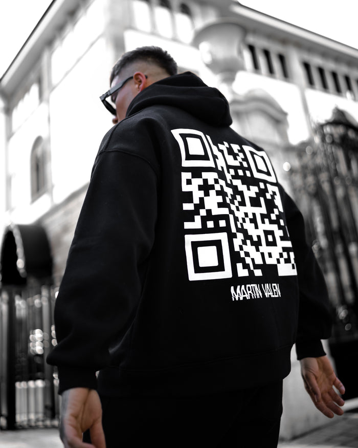 Martin Valen Sigilio black tracksuit set, rear close-up of hoodie showing partial white QR code and raised hood.