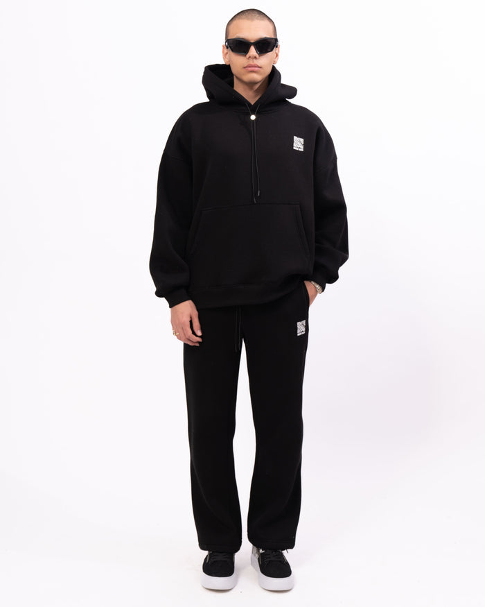 Martin Valen Sigilio black joggers in motion, full-length shot showing white QR code on right thigh