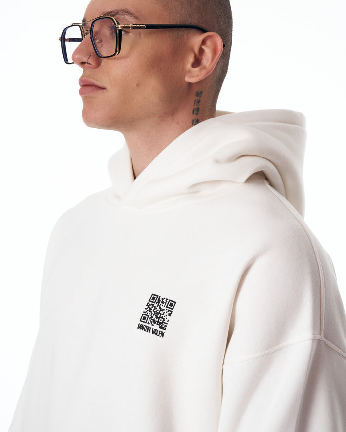 Martin Valen Sigilio oversized white hoodie, right-profile close-up showing small QR code printed on chest