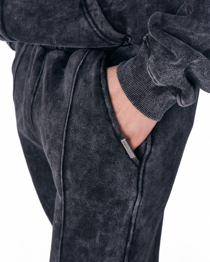 Martin Valen Urban Style washed anthracite tracksuit, mid-body side view with hood up and hand placed on chest