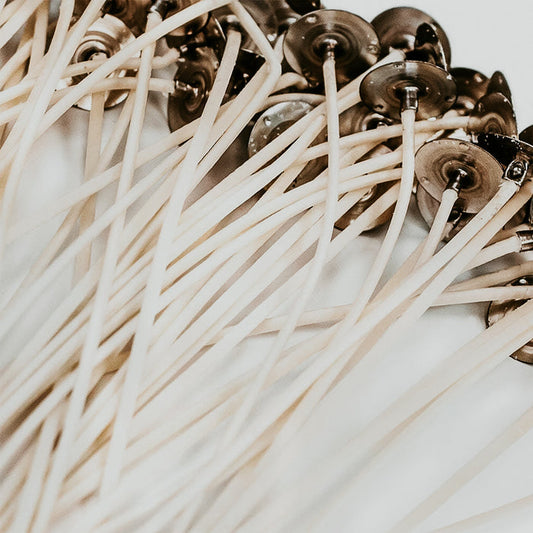 A close-up of zinc-core wicks with braided cotton exterior, prepared for candle making.