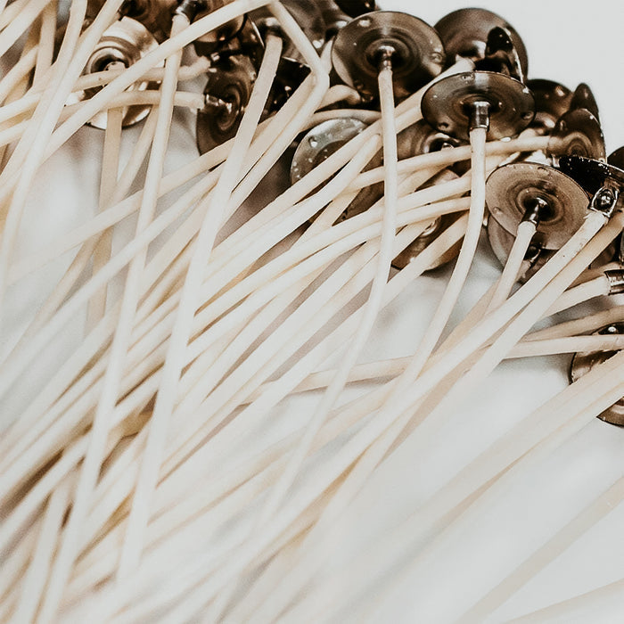 A close-up of zinc-core wicks with braided cotton exterior, prepared for candle making.